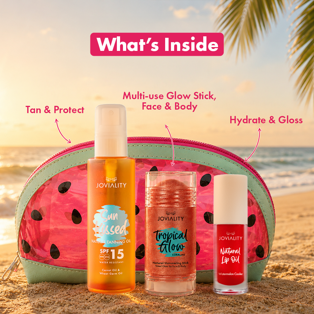 A beach-themed 'What's Inside' product display showing a pink watermelon-pattern makeup bag with three Joviality products in front: an orange body spray bottle sunkissed tanning dry oil, a pink shimmering coral glow stick in a clear container, and a red lip oil bottle watermelon flavor. Text callouts point to each item against a sandy beach and ocean background.
